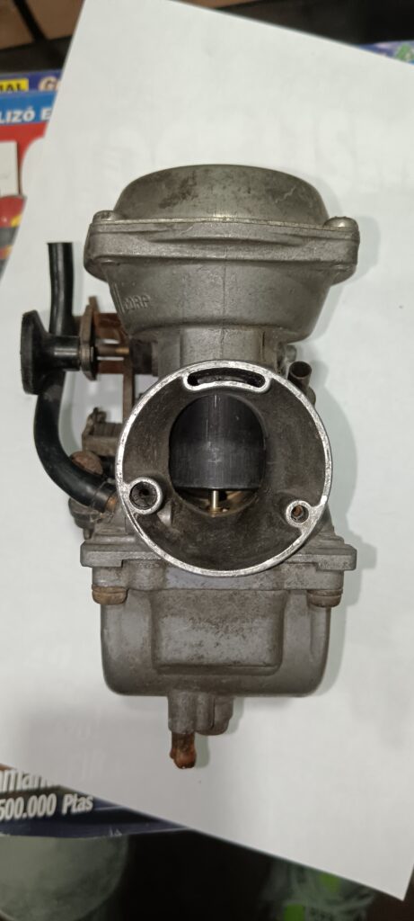 Vista de la mariposa y conducto de salida del carburador original Mikuni para Suzuki GN 250.