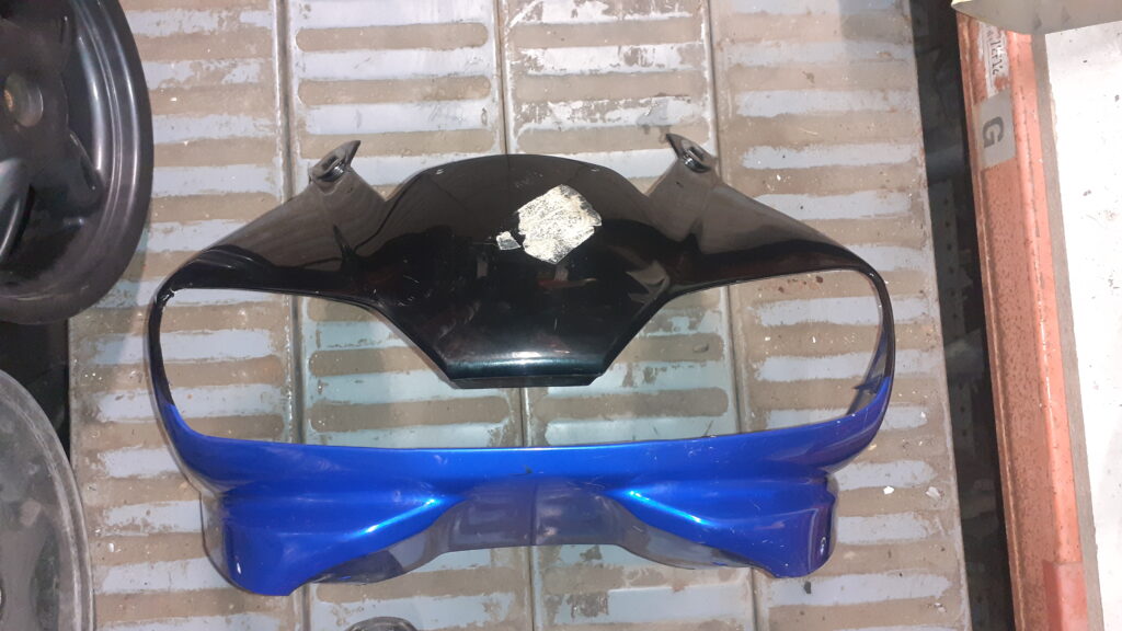 Carenado frontal original para motocicleta deportiva, bicolor negro y azul metálico. Pieza de carrocería recuperada con desconchón visible en la pintura de la zona negra central. Recambio de desguace verificado en Vayafaba.