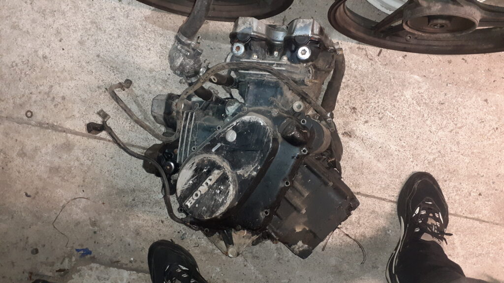 Motor completo Honda VF 500 V4 de los años 80. Bloque motor original recuperado para despiece o restauración. Se observa la arquitectura en V característica y tapas laterales Honda. Pieza mecánica en estado bruto de conservación.