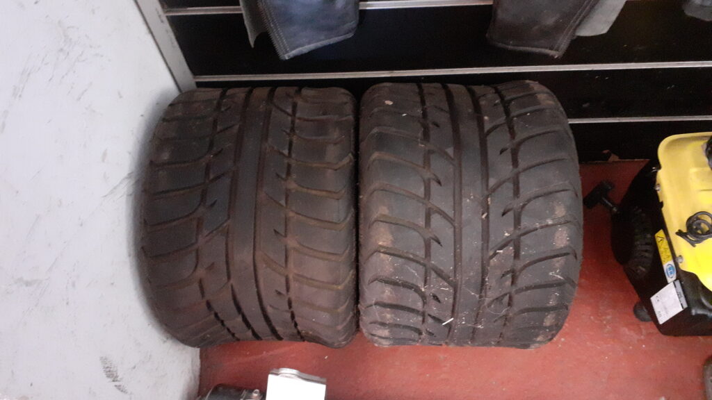 Vista cenital de pareja de neumáticos nuevos a estrenar Maxxis Spearz 255/40-10 para quad de carretera. Banda de rodadura de asfalto con pelos de fabricación intactos en el almacén de Vayafaba.
