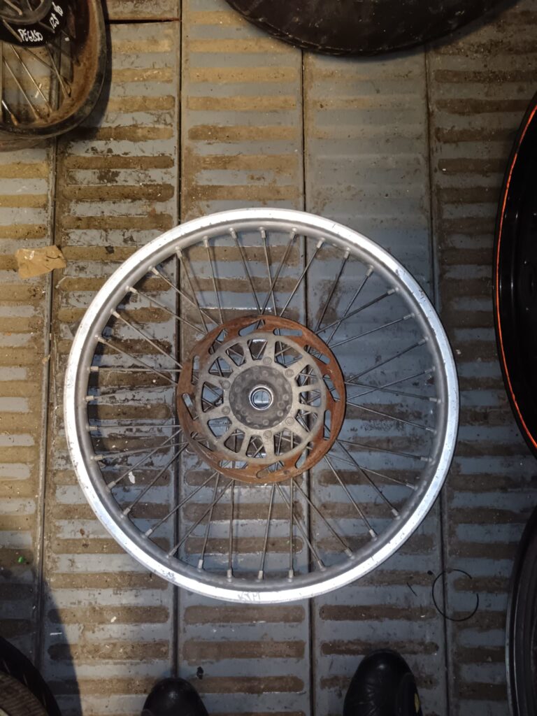Llanta delantera de radios para KTM 125 modelo 2003, vista detallada del lado con disco de freno original.