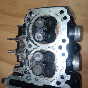 Plano inferior de culata Kawasaki ZZR 250 mostrando las cámaras de combustión y el estado de las ocho válvulas.