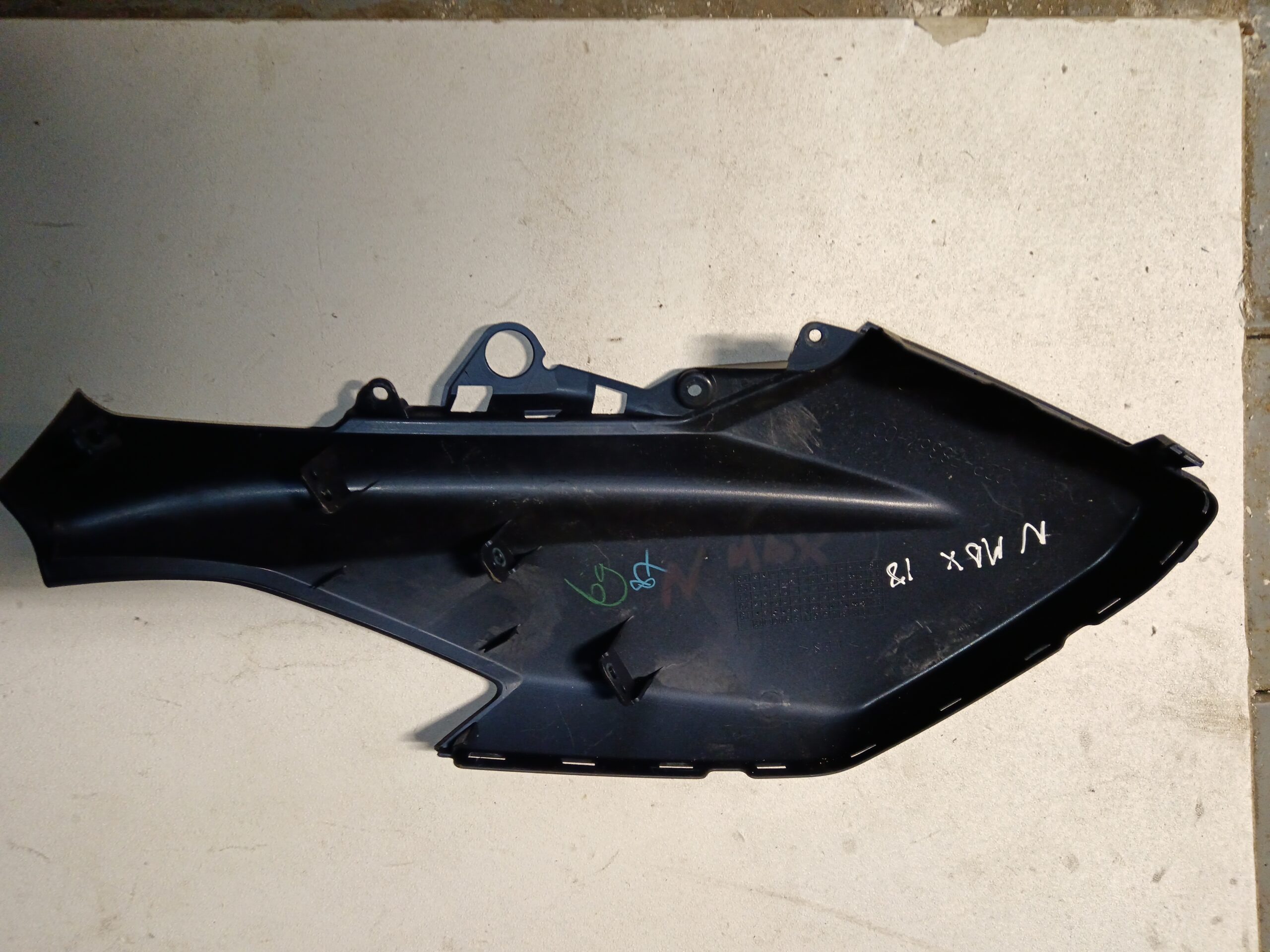 Reverso verificado de la quilla izquierda original Yamaha NMAX azul oscuro satinado (tipo cobalto). Vista interior con pestañas de fijación y marcas de despiece (NMAX 18) en Vayafaba.