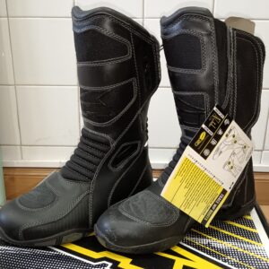 Par de botas de moto negras impermeables AXO TRACE WP talla 41, con etiqueta colgante en la bota derecha.