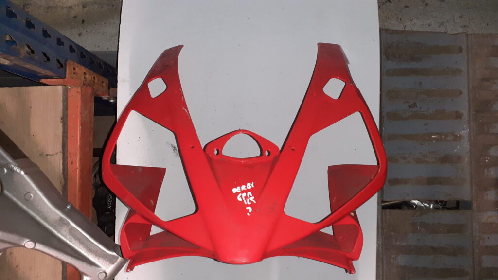 Carenado frontal exterior rojo para Derbi GPR 125. Vista frontal de la pieza pintada con marcajes de inventario blancos.