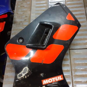 Carenado lateral derecho usado para Yamaha TZR 80 (1989-90). Color negro con adhesivos rojos, Motul y marca Yamaha visibles.