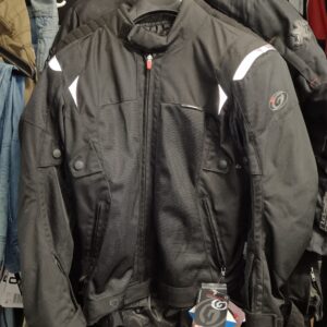 Chaqueta de moto de malla Garibaldi negra colgada en una tienda. Muestra paneles de ventilación, detalles reflectantes y etiquetas de marca.