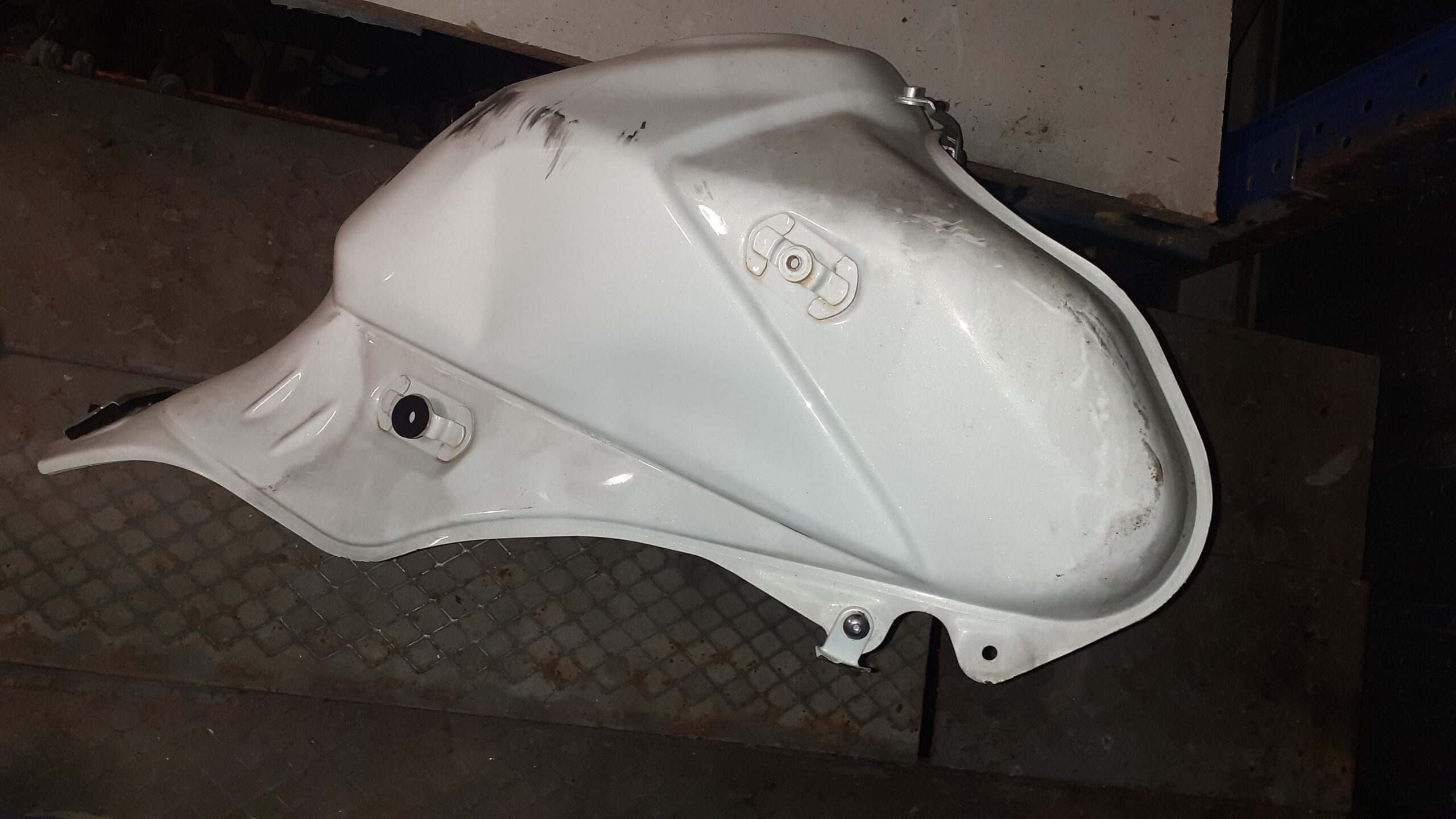 Vista lateral derecha de depósito Suzuki V-Strom 650 2011 blanco. Se observa el estado de la pintura y anclajes laterales.