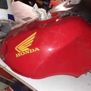 Depósito de gasolina rojo original para Honda CBR 900 RR de 1992 en un estante de desguace.