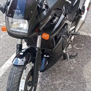 Vista frontal de moto Kawasaki GPZ 500 negra de 1991 con escape Akrapovič, revisada en VAYAFABA, Villaviciosa, Asturias.