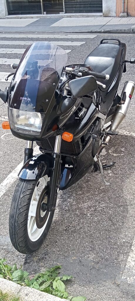 Vista frontal de moto Kawasaki GPZ 500 negra de 1991 con escape Akrapovič, revisada en VAYAFABA, Villaviciosa, Asturias.