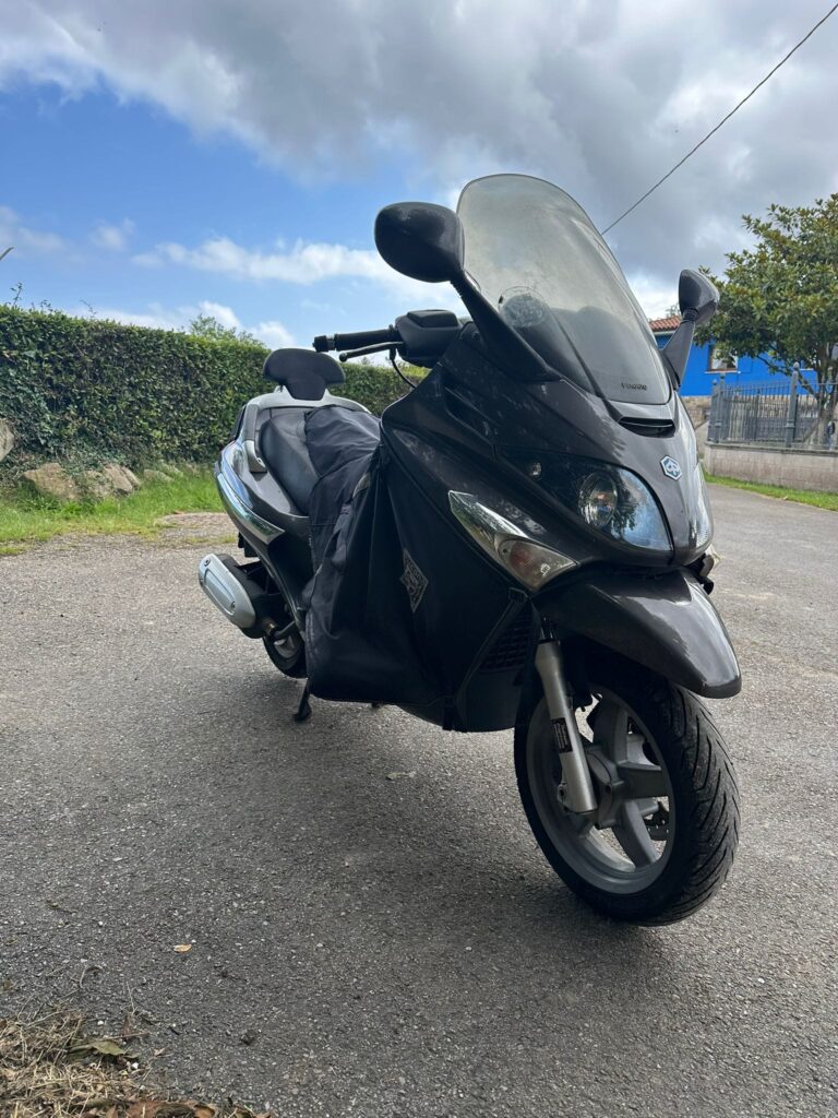 Scooter Piaggio X9 Evolution gris oscuro de segunda mano con manta térmica Tucano Urbano y cúpula alta en venta.