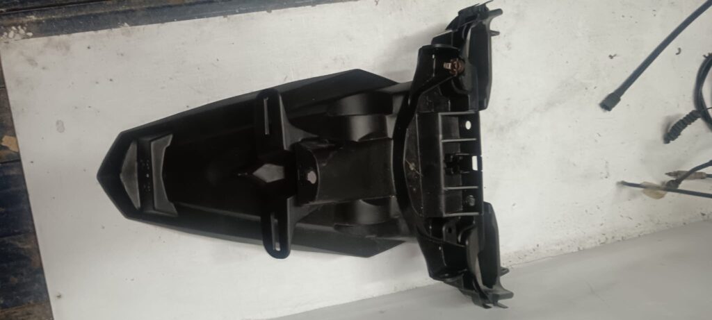 Portamatrículas original trasero para Yamaha TZR 50, fabricado en plástico técnico negro, recambio verificado en VAYAFABA.