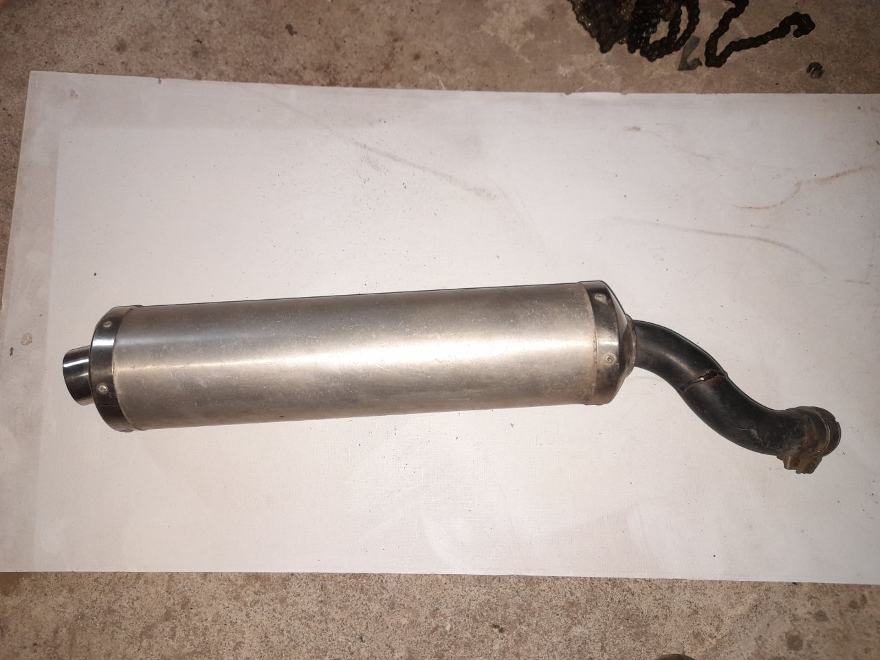 Silencioso de escape Yamaha R6 con codo adaptador para Honda VFR 750. Cuerpo metálico cepillado sobre fondo blanco.