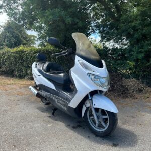 Scooter Suzuki Burgman 125cc blanca del año 2005 en venta de segunda mano, vista frontal diagonal en exterior asfaltado.