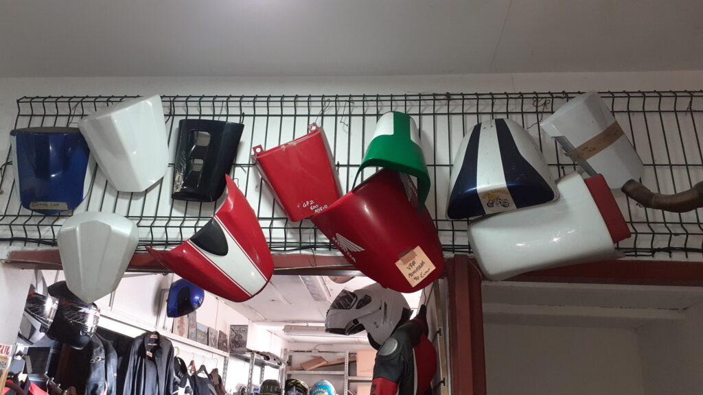 Varias tapas de asiento trasero monoplaza y colines para motos de diferentes marcas y modelos expuestos en VAYAFABA.