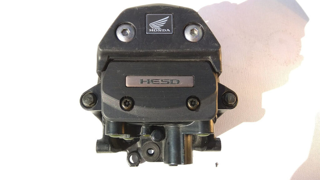 Vista frontal del amortiguador de dirección electrónico original HESD con logotipo de marca para Honda CBR 1000 RR de los años 2004 y 2005.