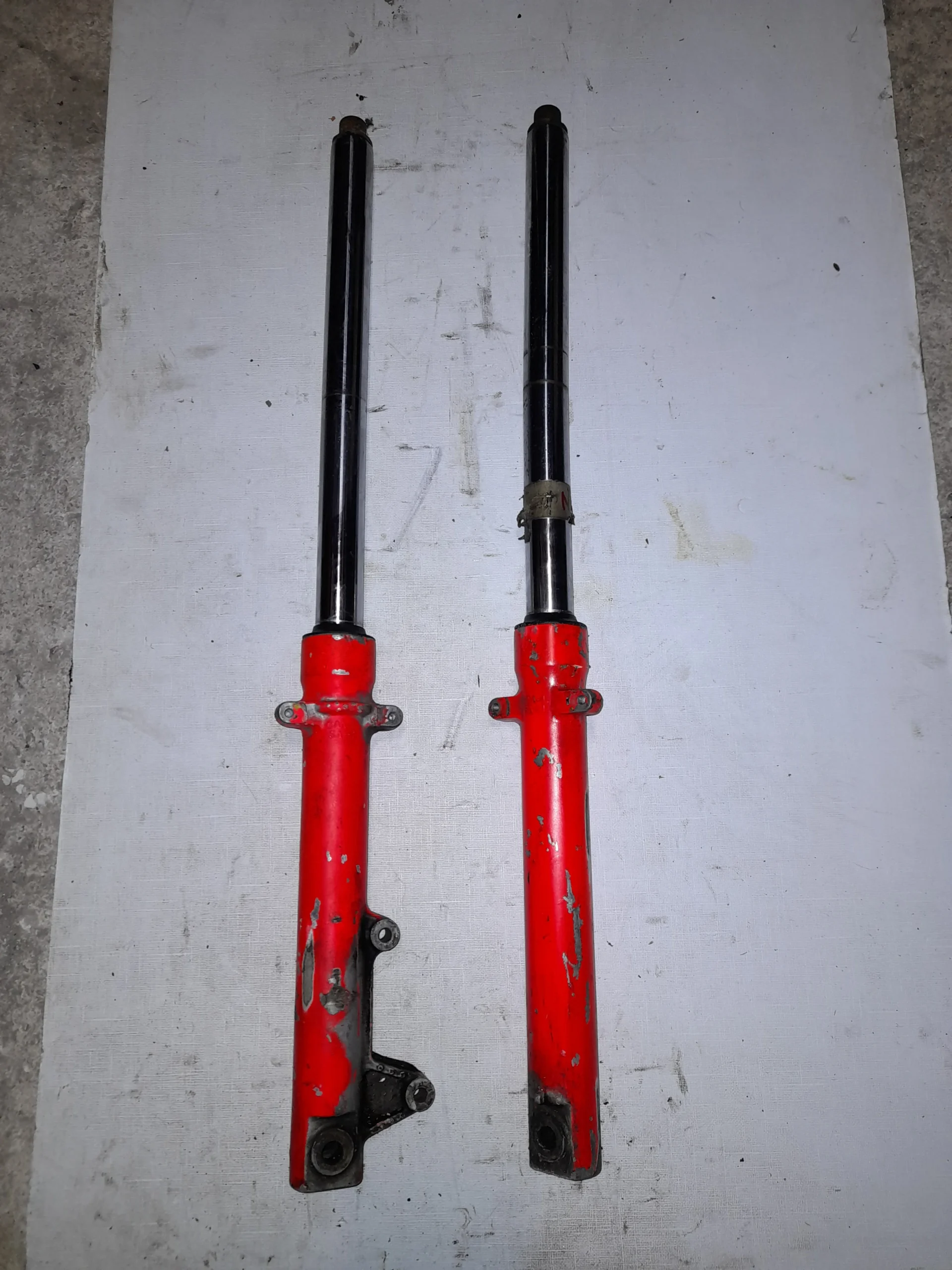 Pareja de barras de horquilla delanteras originales para moto Honda NS1 125 modelos 1993 a 1995 en color rojo.