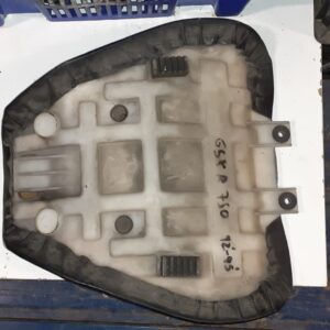 Vista inferior de la base de plástico de un asiento delantero usado de Suzuki GSX-R 750 (1992-1995) sobre una estantería.