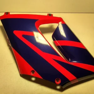 Vista exterior del carenado lateral izquierdo original en colores azul y rojo con soportes intactos para motocicleta Honda CBR 125 R.