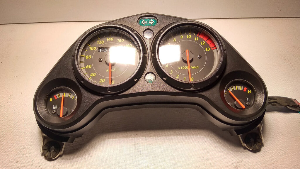 Vista frontal del cuadro de instrumentos analógico con velocímetro y cuentarrevoluciones original para motocicleta Honda CBR 125 R años 2004 a 2006.