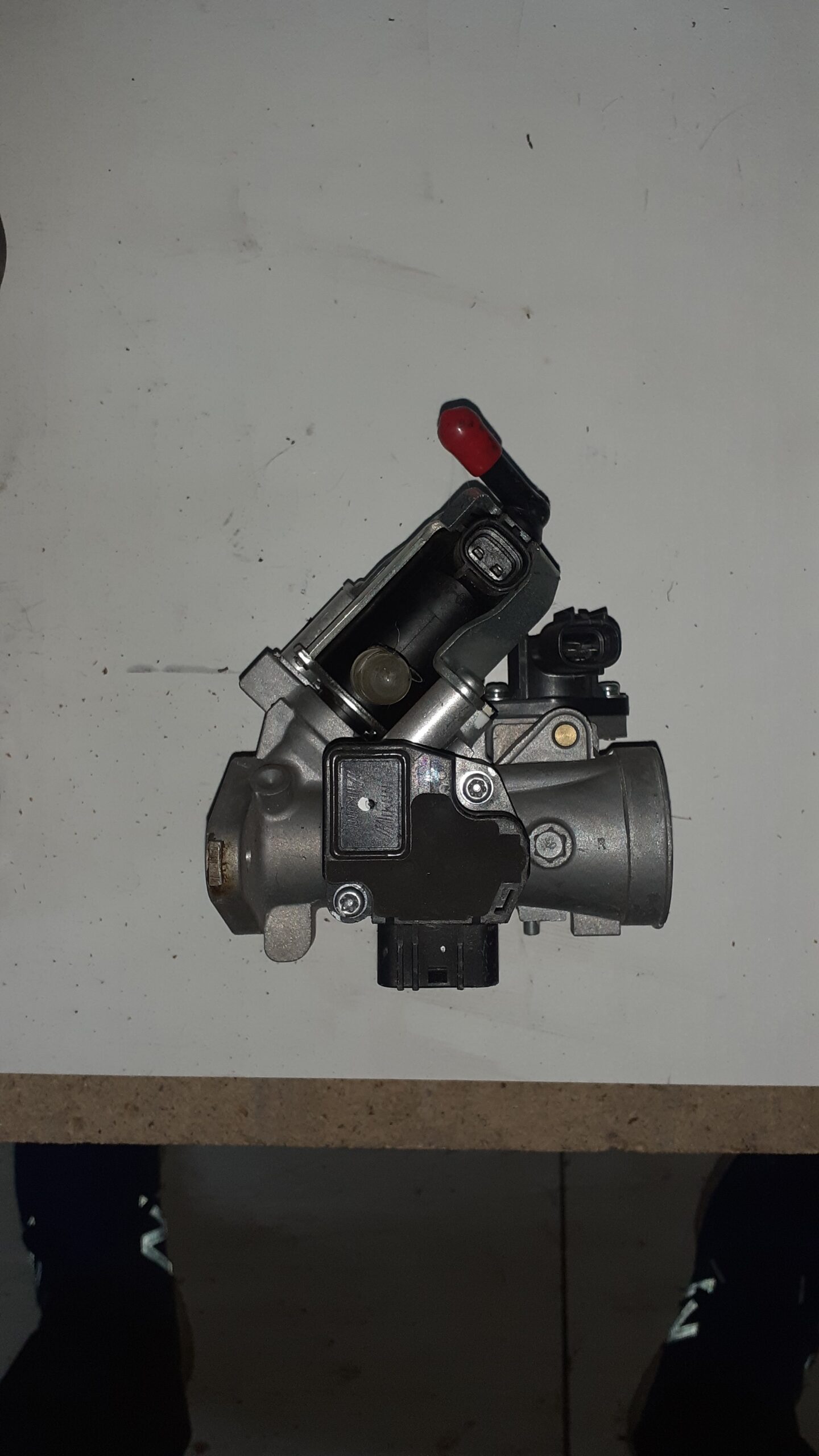 Sensores y conectores electrónicos de un cuerpo de inyección para Suzuki Burgman 125 con detalle de la toma de combustible.