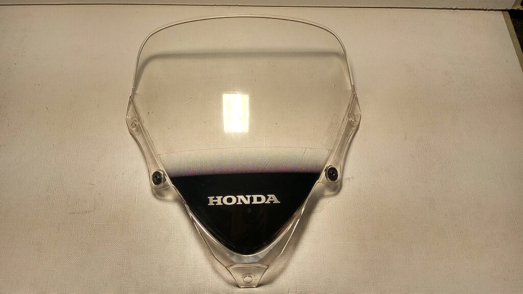 Vista frontal de la cúpula pantalla parabrisas original transparente con logotipo Honda para motocicleta Honda CBR 125 R años 2004 a 2006.