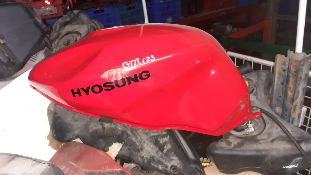 Depósito de gasolina Hyosung GTR 125 rojo. Lateral izquierdo con logotipo original y marcaje de modelo para identificación.