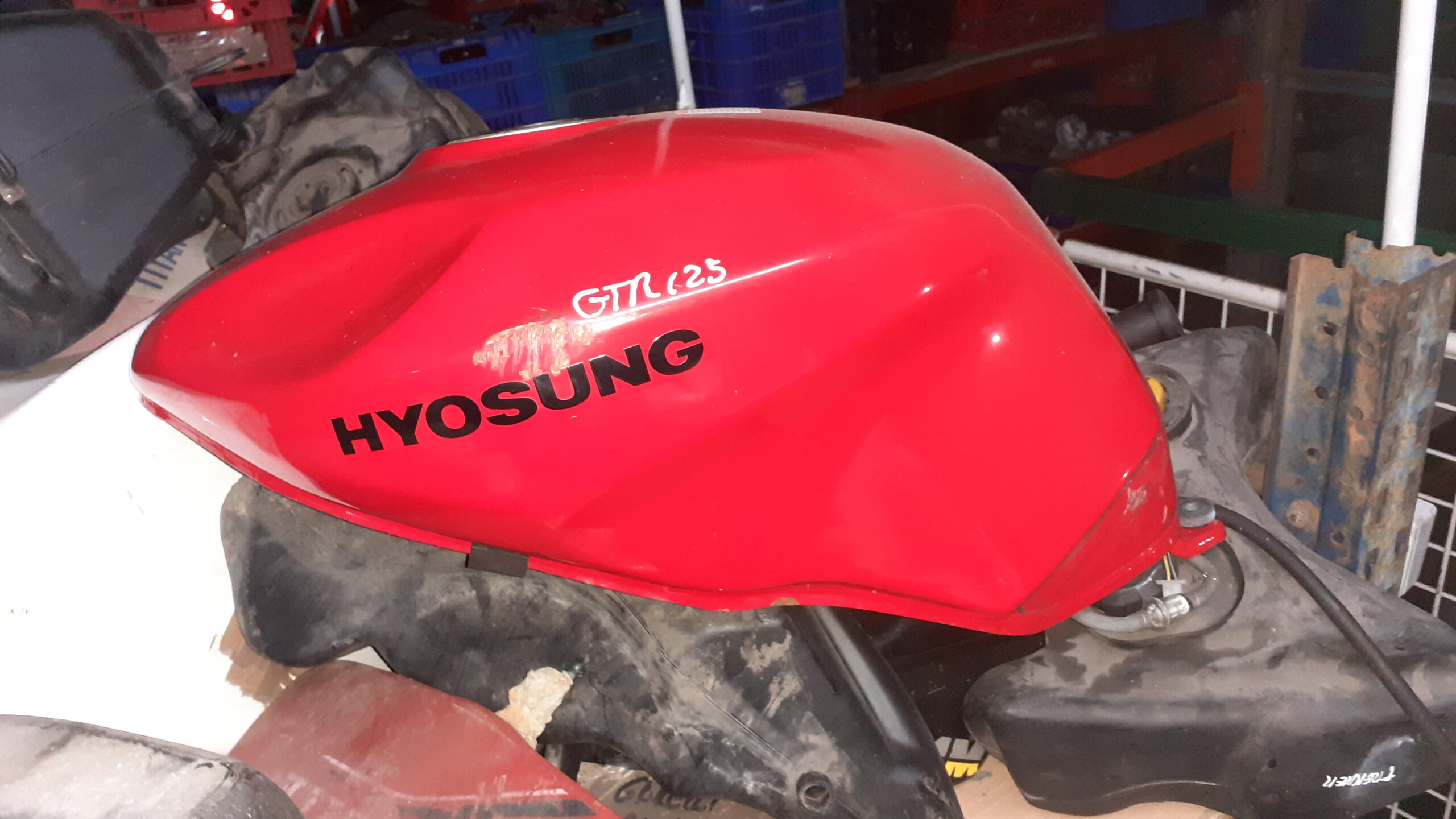 Depósito de gasolina Hyosung GTR 125 rojo. Lateral izquierdo con logotipo original y marcaje de modelo para identificación.