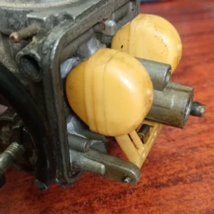 Detalle del sistema de flotador y boyas de un carburador Dellorto PHBH 28, mostrando el eje y el estado de la aguja.