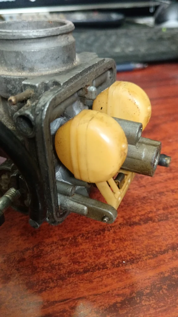 Detalle del sistema de flotador y boyas de un carburador Dellorto PHBH 28, mostrando el eje y el estado de la aguja.