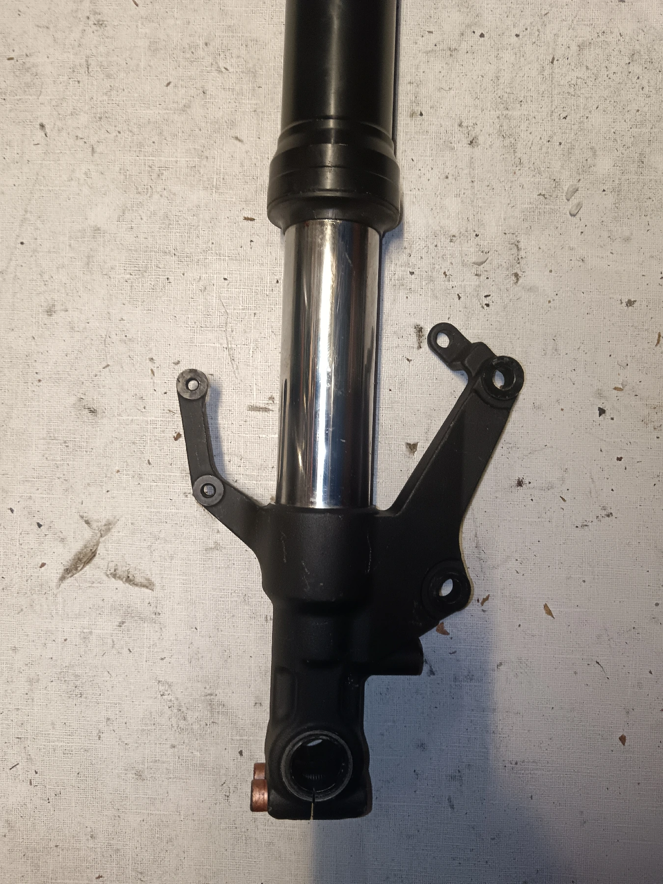 Detalle de puntera y anclaje de pinza de freno de horquilla izquierda para Yamaha R1 2002 RN09 en perfecto estado.