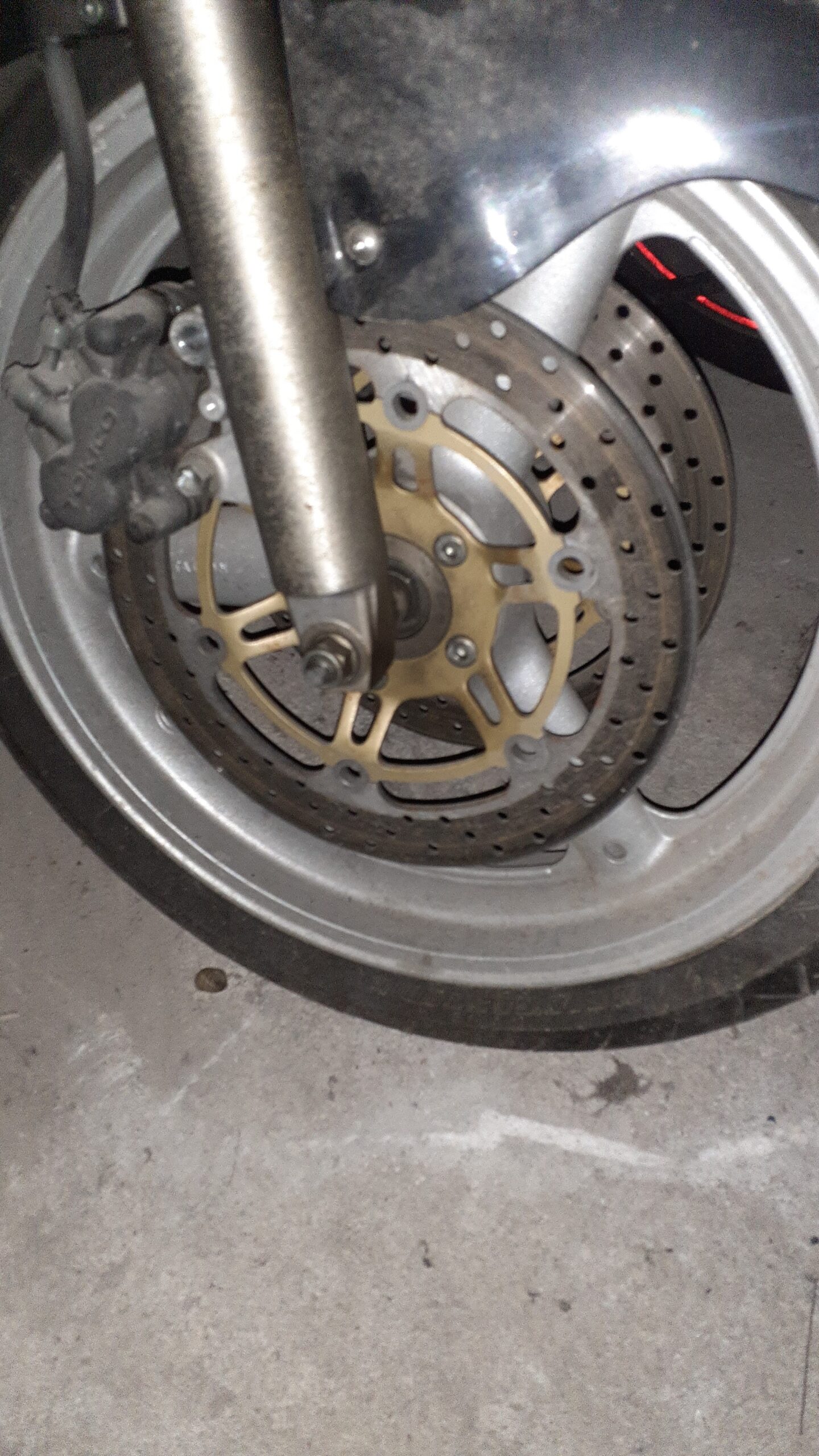 Discos de freno delanteros con núcleo dorado montados en la rueda de una Suzuki Bandit 600 año 2004, con pinza de freno.