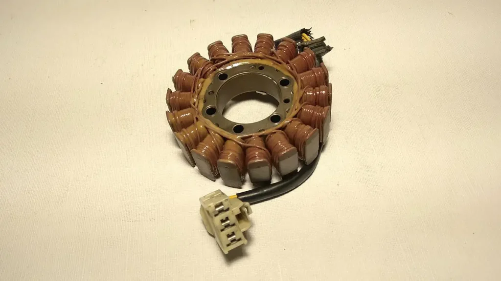 Vista superior del estator de alternador original con bobinado de cobre y clema de conexión para Honda CBR 600 RR 2003.