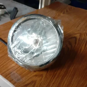 Faro delantero original recuperado para motocicleta Cagiva Electra 125 (1989), óptica con cerquillo cromado.