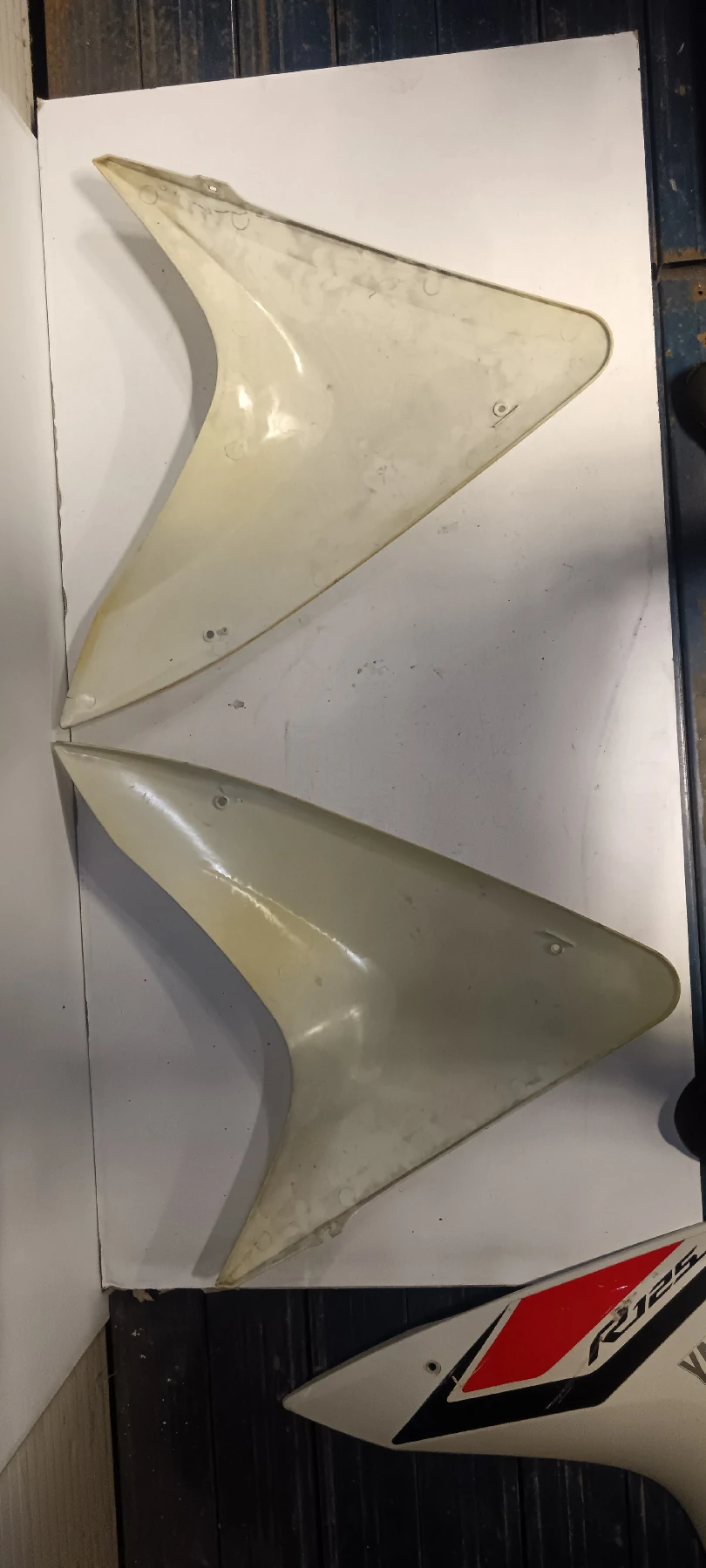 Vista interior del juego de carenados laterales para Yamaha YZF-R125 amarillos. Verificación de soportes y puntos de fijación.