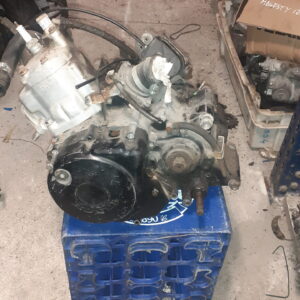 Motor completo Honda NSR 125 JC22 de dos tiempos. Vista general del bloque motor revisado sobre soporte azul en taller.