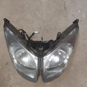 Óptica de faro delantero original para Yamaha T-Max 500. Recambio recuperado y revisado con patillas y conectores intactos.