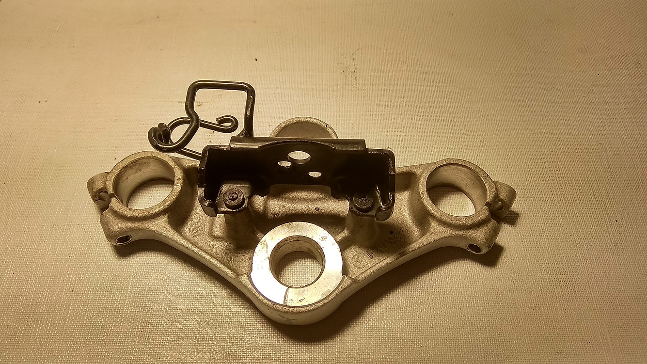Vista inferior de la tija superior original de aluminio con soporte para bombín de encendido y guiado de cables de Honda CBR 125 R.
