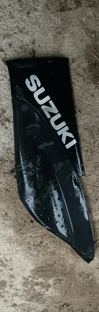 Quilla lateral izquierda para Suzuki Katana 50cc en color negro con logo Suzuki blanco. Recambio original de carrocería.