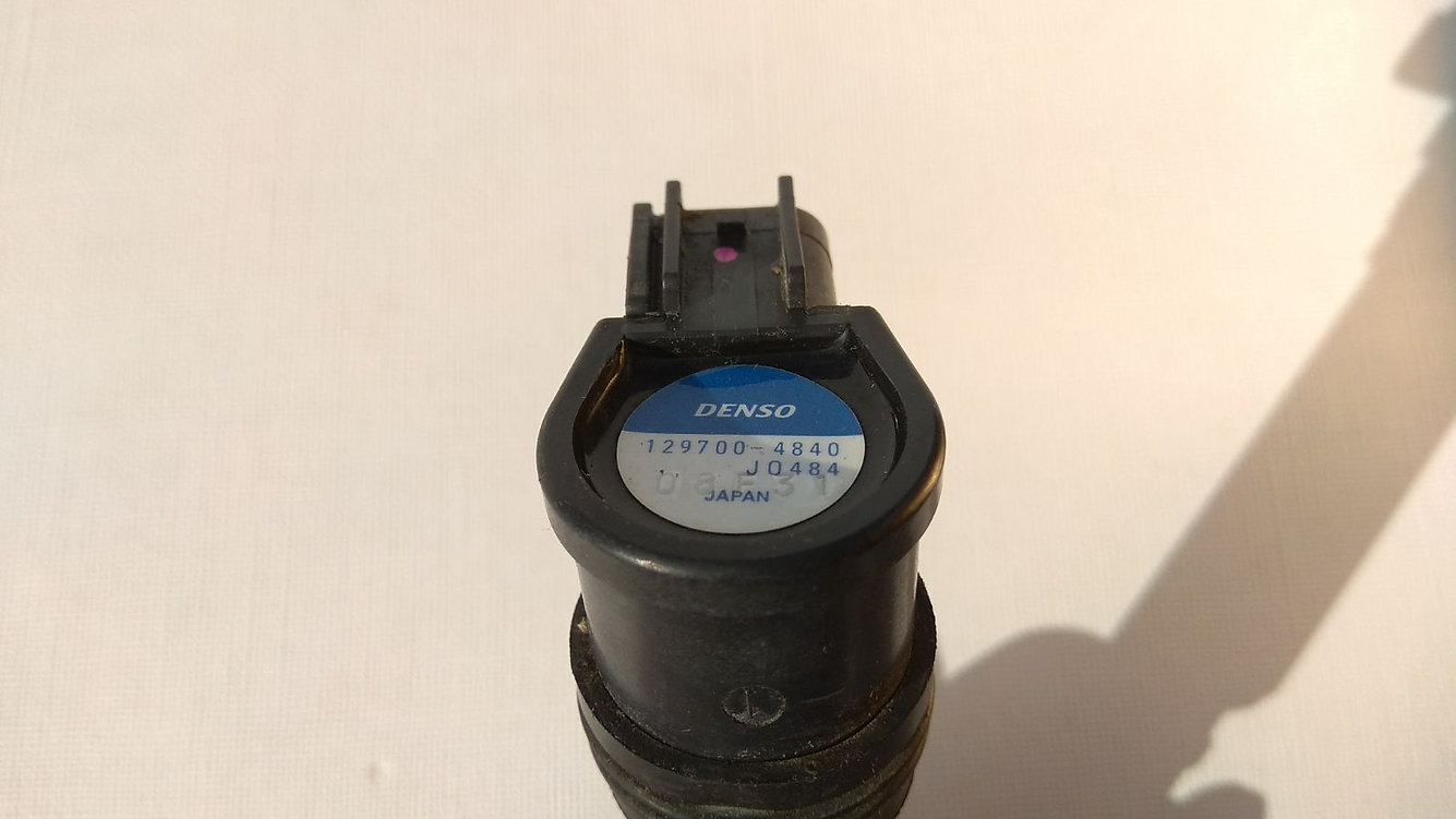 Primer plano de la referencia técnica de fábrica Denso 129700-4840 en la cabeza de la bobina de encendido original para Honda CBR 1000 RR 2004 y 2005.