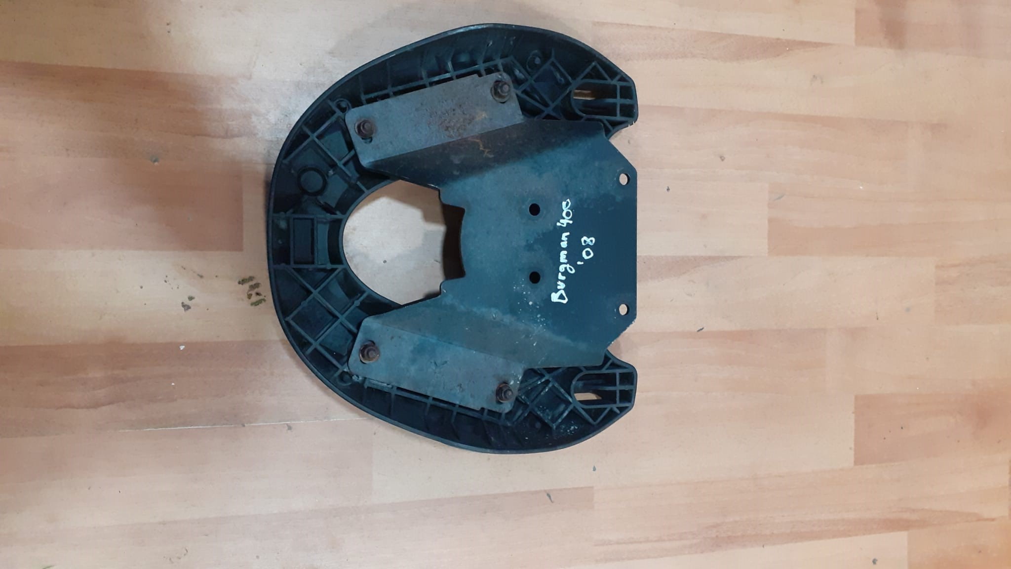 Vista inferior del soporte de baúl trasero original para Suzuki Burgman 400 (2008). Detalle de anclajes de pieza recuperada.