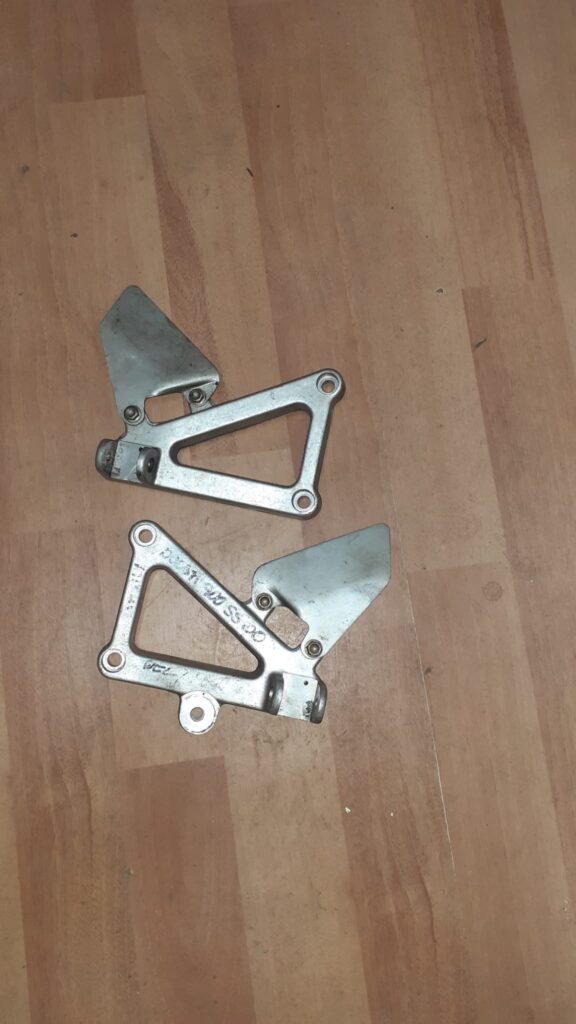 Juego de soportes de estriberas delanteras originales para Ducati 900 SS año 2000. Recambio recuperado en aluminio pulido.