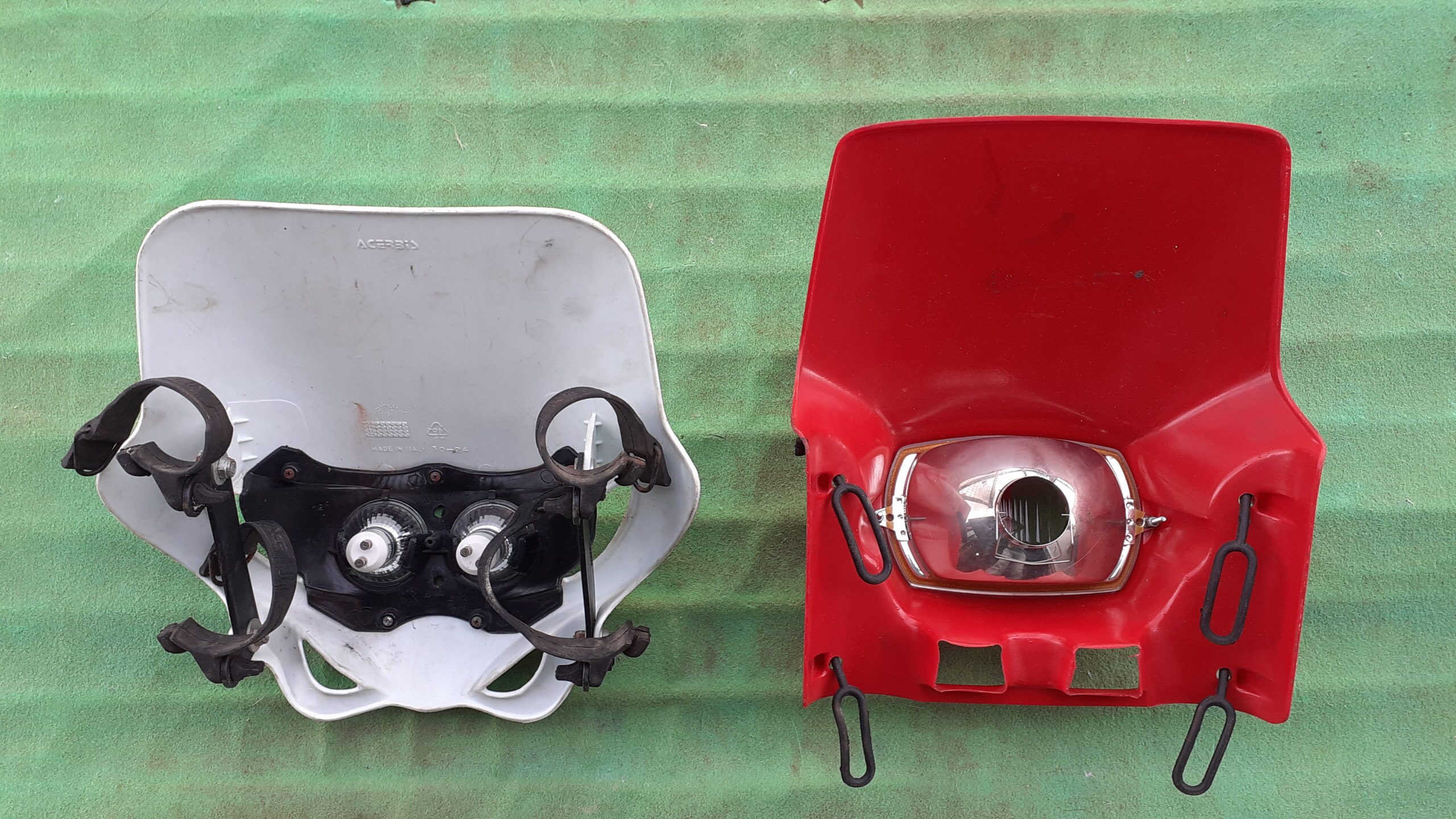 Vista trasera de caretas de faro universales con gomas de sujeción a la horquilla y ópticas instaladas.