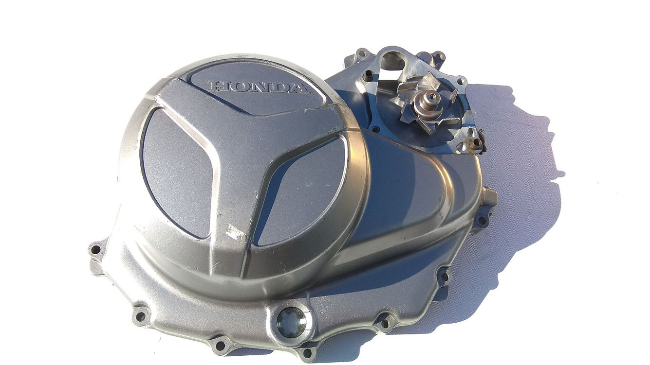 Vista exterior de la tapa de embrague original con mirilla de aceite y módulo de bomba de agua integrado para Honda XL 1000 V Varadero.