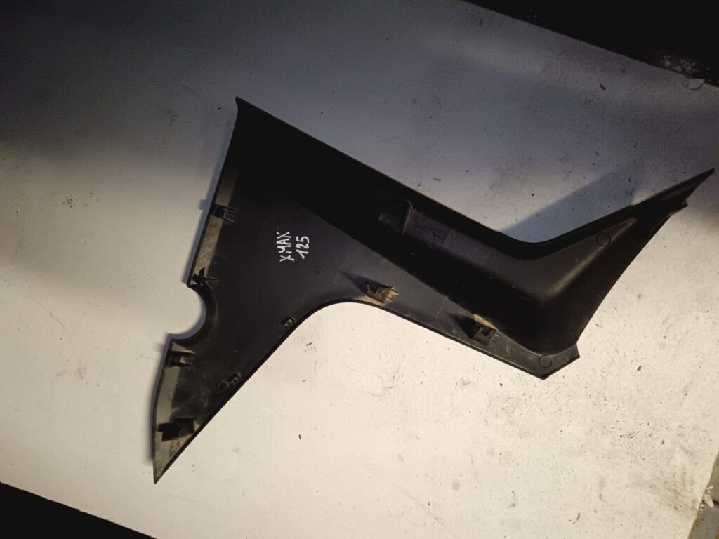 Vista interna de la tapa lateral boomerang derecha para Yamaha X-MAX 125. Detalle de anclajes y soportes originales intactos.