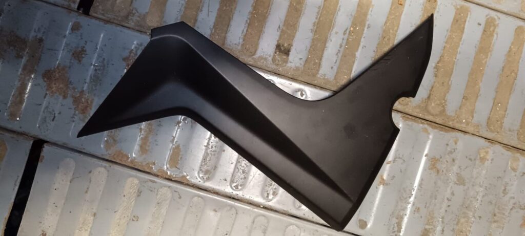 Tapa lateral tipo bumerán izquierda para Yamaha X-MAX 125 (2010-2013). Embellecedor de túnel central en plástico negro mate.