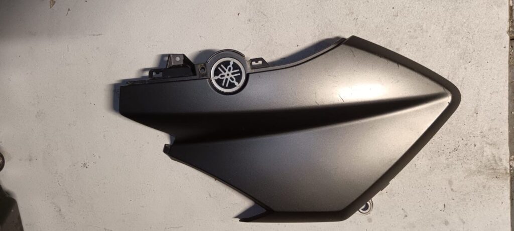 Tapa lateral derecha de carenado para Yamaha X-MAX 125 año 2013. Protector original en color gris mate con logo Yamaha.