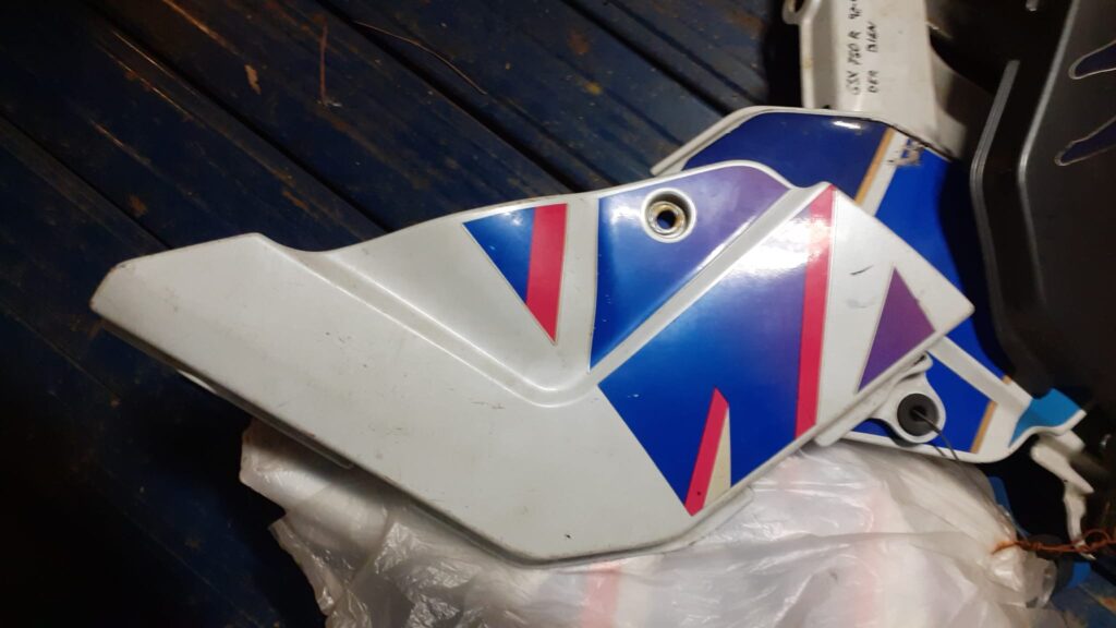 Tapa lateral derecha protector de chasis original para Suzuki GSXR 750 año 1992. Carenado en color blanco, azul y rosa.