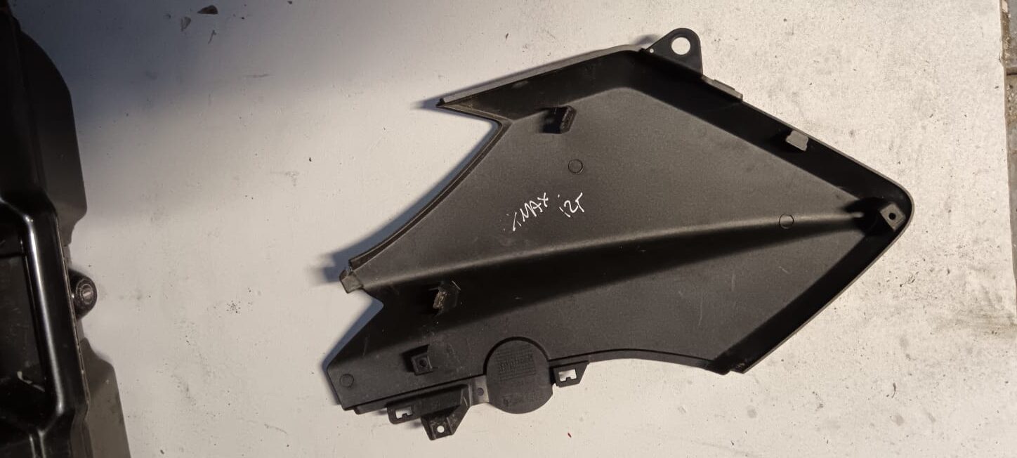 Vista interna de la tapa lateral derecha para Yamaha X-MAX 125 (2013). Detalle de los puntos de anclaje y soportes plásticos.